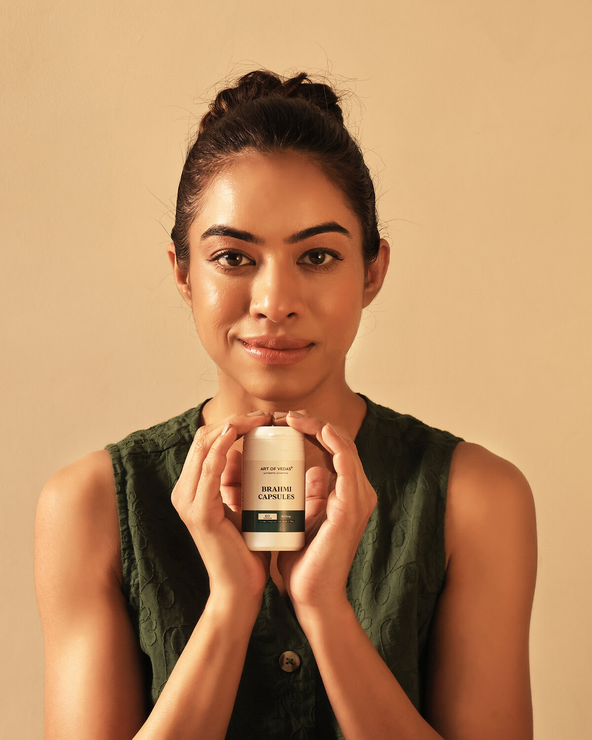 Art of Vedas Brahmi Capsules held by a model